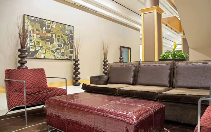 Sitting area in the lobby of the Florida Hotel featuring a brown couch and red chait.