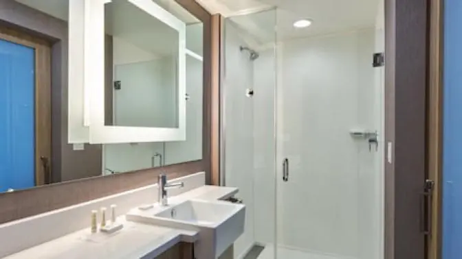 Contemporary bathroom at SpringHill Suites with a bright, well-lit vanity area, clean white fixtures, and elegant decor accents.