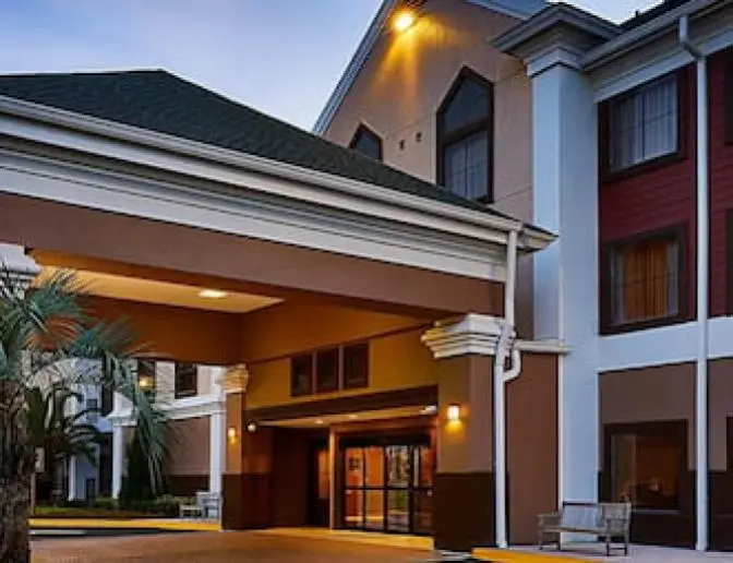 Staybridge Suites Orlando International Airport Hotel main entryway, showcasing the covered entrance and warm exterior lighting at dusk.