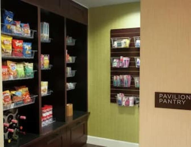 Market at the Hilton Garden Inn Orlando Airport Hotel with shelves stocked with snacks, drinks, and toiletries, labeled as Pavilion Pantry.