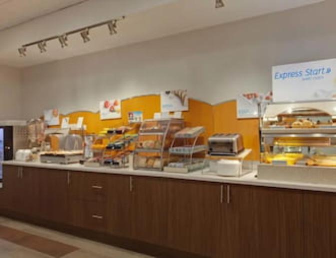 Holiday Inn Express Orlando International Airport Hotel breakfast buffet featuring hot breakfast items.