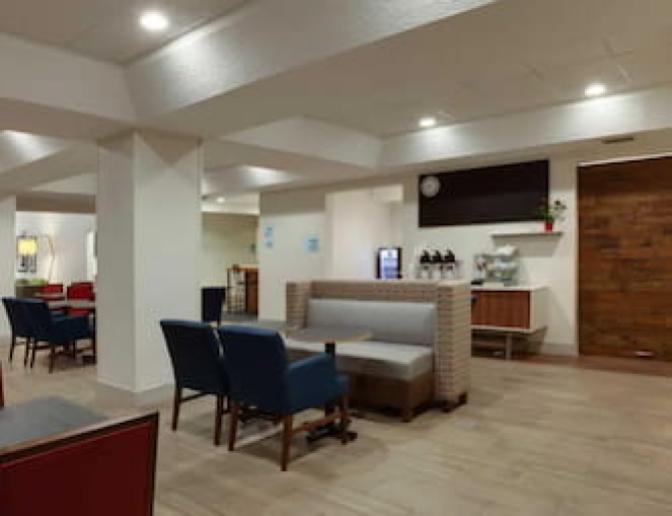 Warm spacious dining area inside Holiday Inn Express Orlando International Airport Hotel featuring a coffee bar.