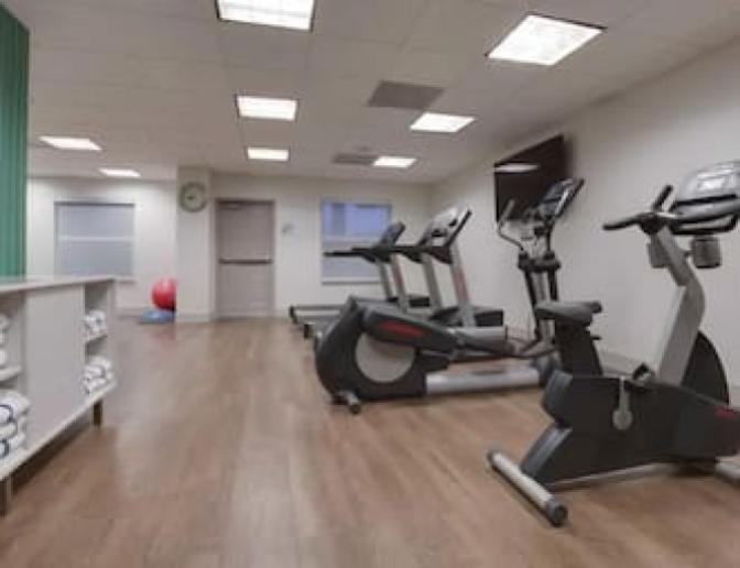 Bright and spacious gym featuring a stationary bike, elliptical and treadmill.