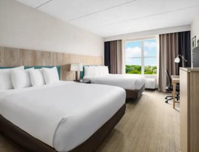 A room that has two Queen beds at the Country Inn & Suites near Orlando Airport.
