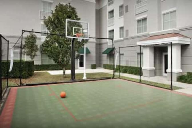 Outdoor patio featuring a basketball court in the center of a courtyard at Homewood Suites by Hilton near Orlando Airport.