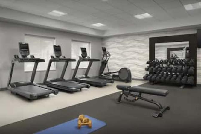 Spacious bright gym inside Homewood Suites by Hilton near Orlando Airport featuring cardio gym equipment.