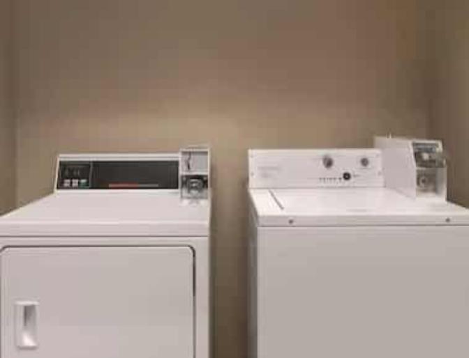 Side by side washing machine and dryer inside Country Inn & Suites near Orlando Airport.