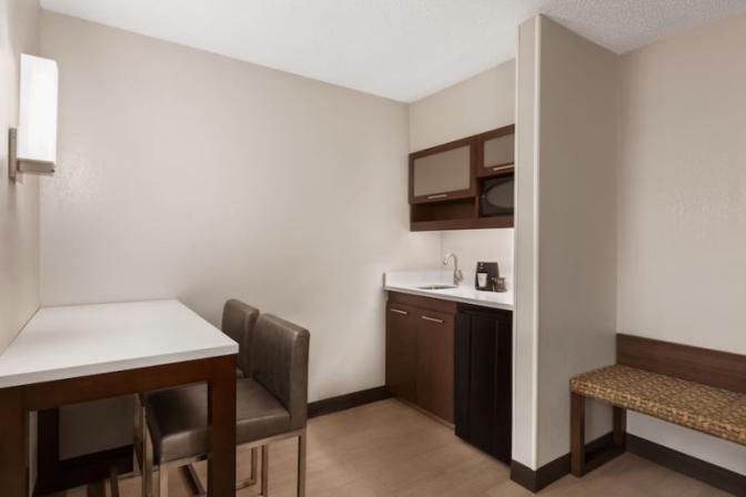 Kitchenette in Ramada Suites king room featuring a mini refrigerator, microwave, sink and coffee maker.
