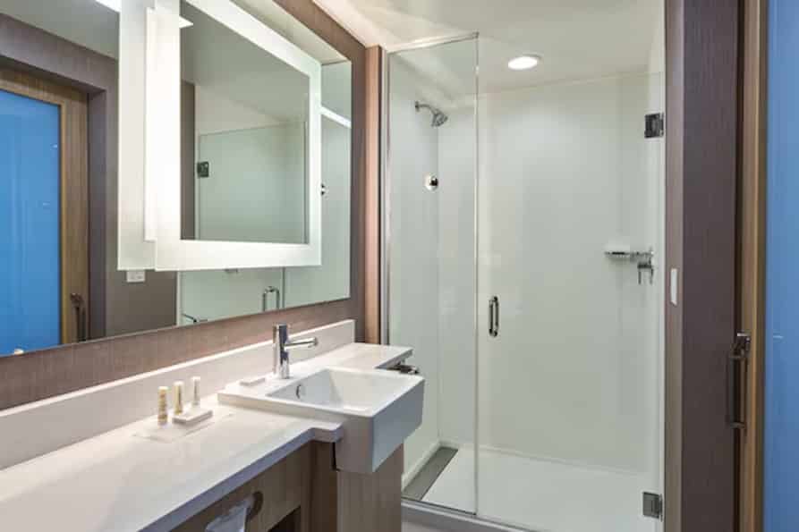 Contemporary bathroom at SpringHill Suites with a bright, well-lit vanity area, clean white fixtures, and elegant decor accents.