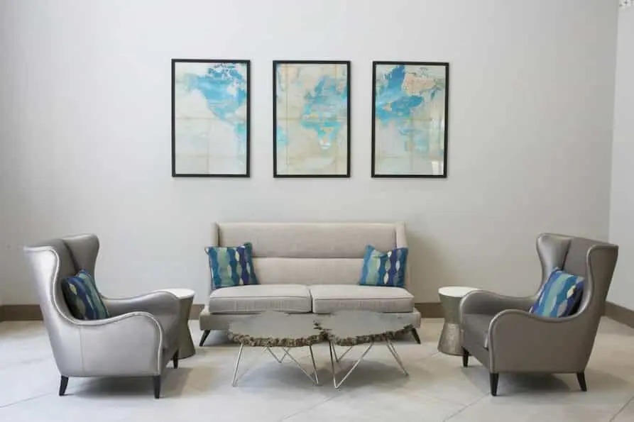 Bright and spacious Holiday Inn Orlando International Airport lobby featuring modern decor with colorful abstract wall art, yellow and beige seating, and ample natural light.