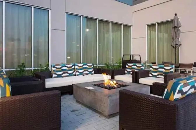 Outdoor firepit in the courtyard of the TownePlace Suites near Orlando Airport, featuring comfortable outdoor couches with geometric patterned cushions.