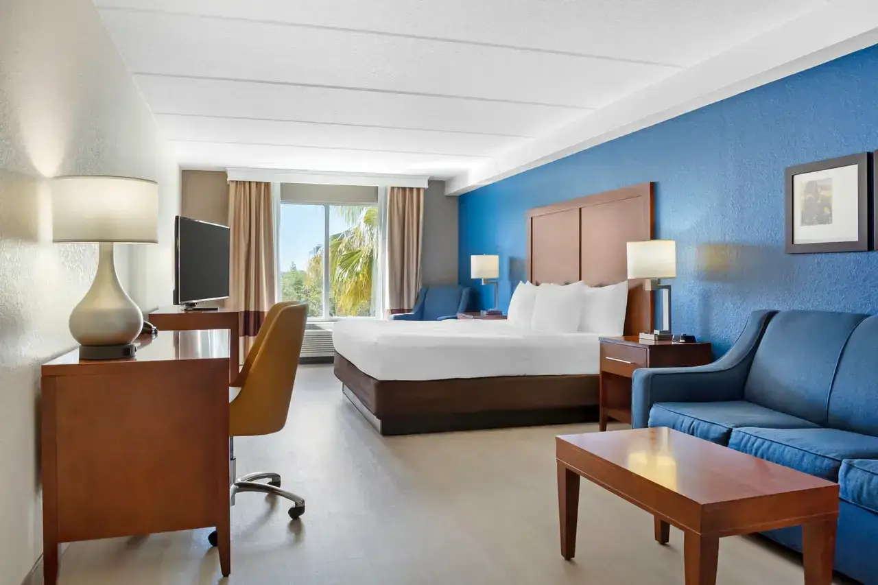 Spacious Comfort Inn & Suites room with a king-sized bed, nightstands, and framed artwork above the couch.