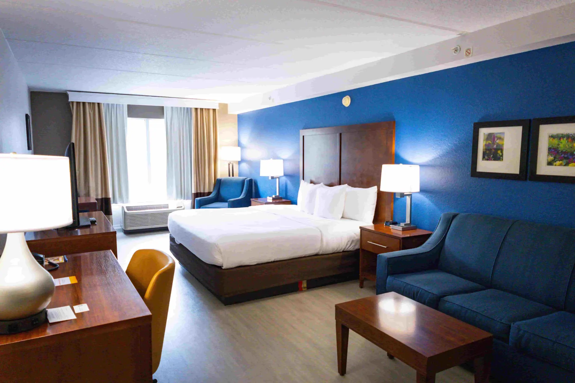 Spacious Comfort Inn & Suites room with a king-sized bed, nightstands, and framed artwork above the couch.