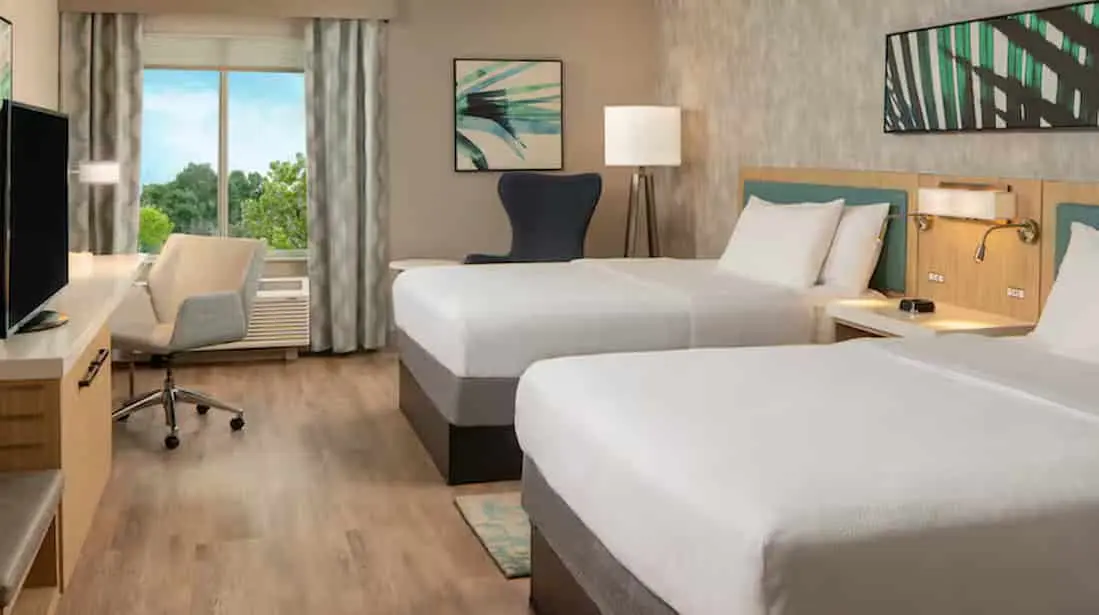 Elegant hotel room with a queen bed, modern decor, and convenient amenities for a comfortable stay.