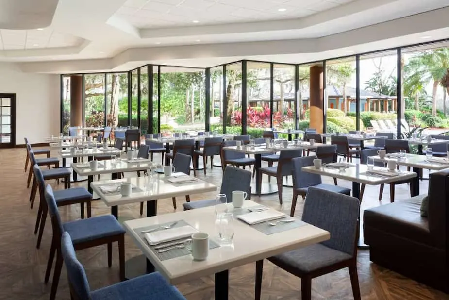 Modern dining space at Marriott Lakeside, showcasing elegant tables and chairs, and expansive windows overlooking the garden.