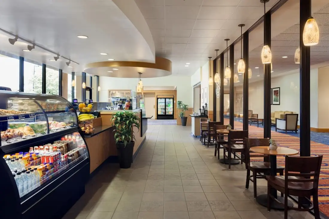 Marriott Lakeside café with a selection of sandwiches, drinks, and fresh fruit, alongside seating and pendant lighting.