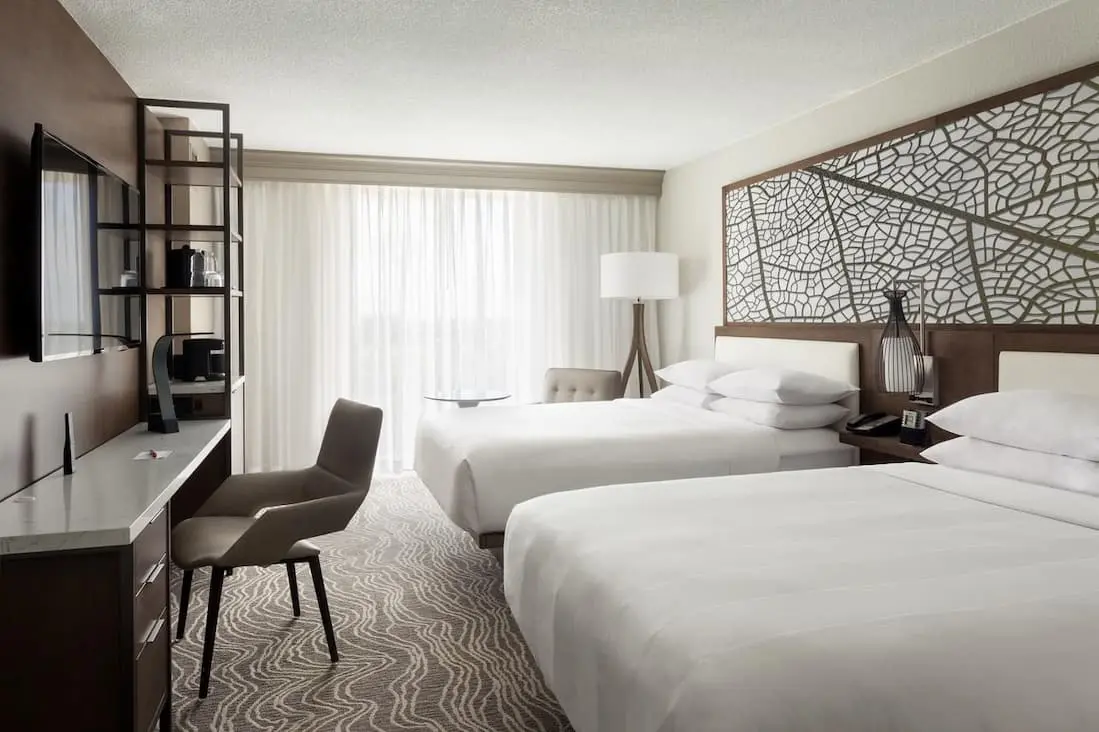 Comfortable hotel room with two queen beds, desk, and modern furnishings.