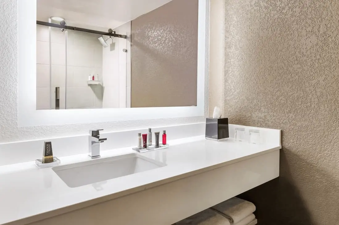 Contemporary bathroom featuring a spacious counter, illuminated mirror, and modern fixtures.