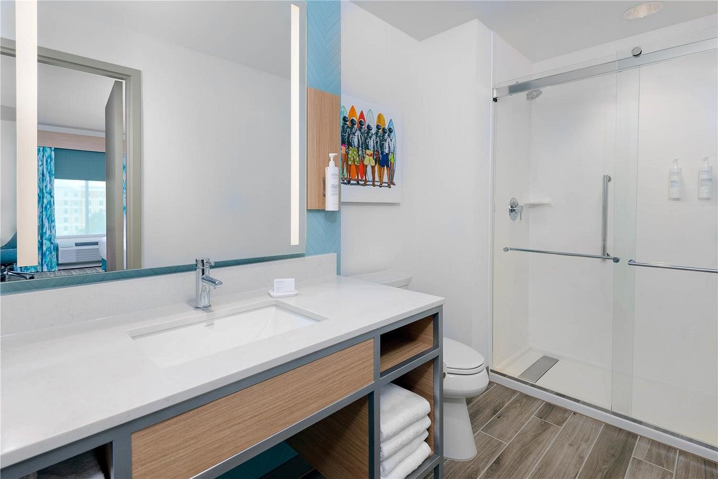 Spacious bathroom with walk-in shower and coastal decor at Hilton Garden Inn Cape Canaveral near Cocoa Beach.