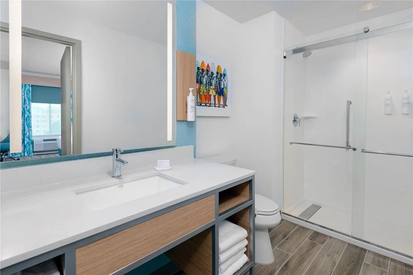 Spacious bathroom with walk-in shower and coastal decor at Hilton Garden Inn Cape Canaveral near Cocoa Beach.
