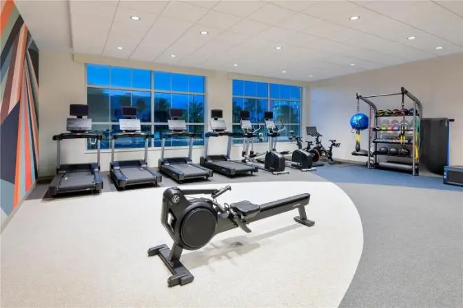 Fully equipped fitness room with free weights, resistance machines, and cardio equipment at Hilton Garden Inn Cape Canaveral near Cocoa Beach.