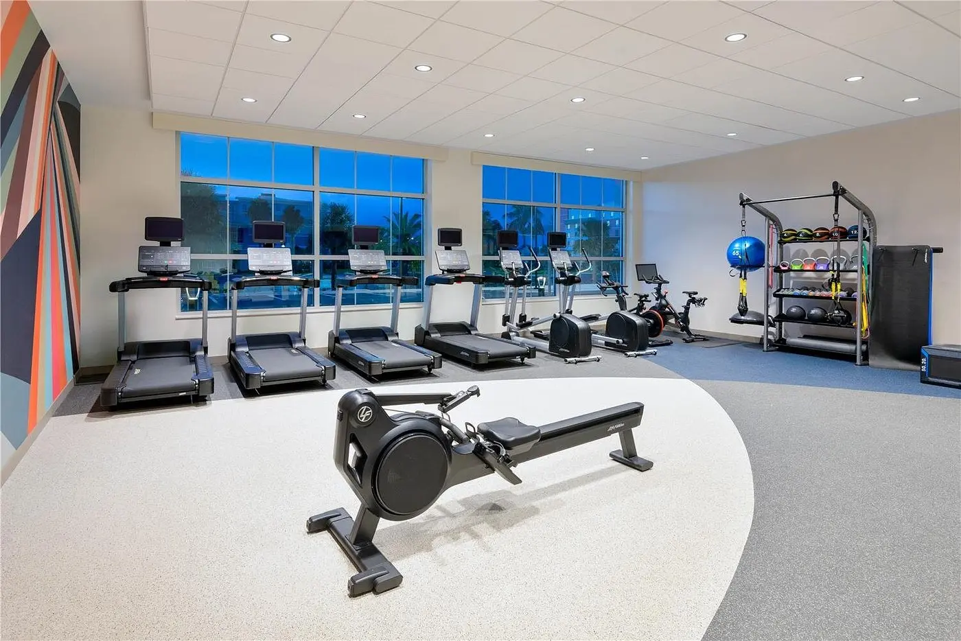 Fully equipped fitness room with free weights, resistance machines, and cardio equipment at Hilton Garden Inn Cape Canaveral near Cocoa Beach.