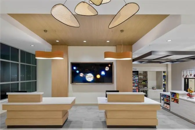 Front desk and lobby area with modern lighting and artwork at Hilton Garden Inn Cape Canaveral near Cocoa Beach.