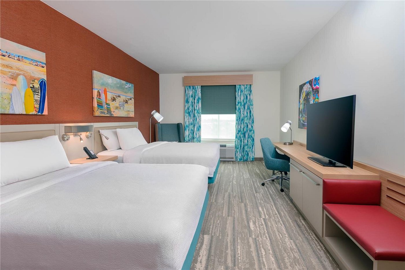 Double queen guest room with modern decor, workspace, and coastal artwork at Hilton Garden Inn Cape Canaveral near Cocoa Beach.