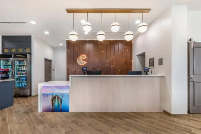 Reception area at Comfort Inn & Suites Sanford hotel showcasing a stylish front desk and modern amenities in the lobby.