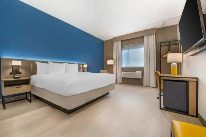 Spacious Comfort Inn & Suites room with a king-sized bed, nightstands, and a large TV.